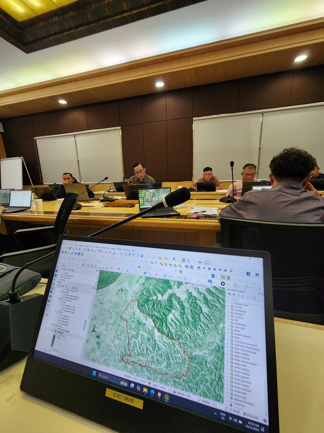 A project team reviewing a SastenaLens dashboard on screen